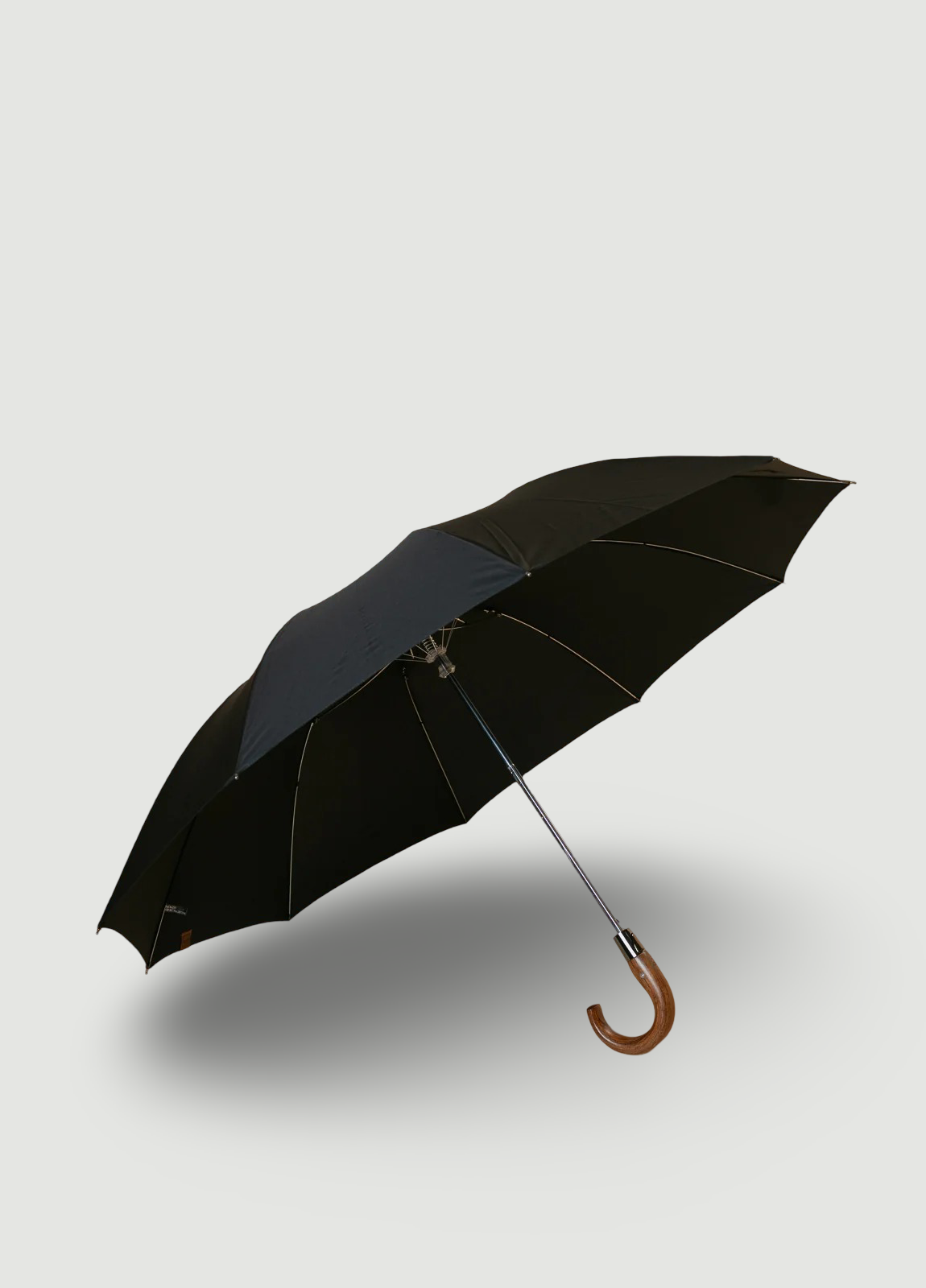 Black folding umbrella with wooden handle.