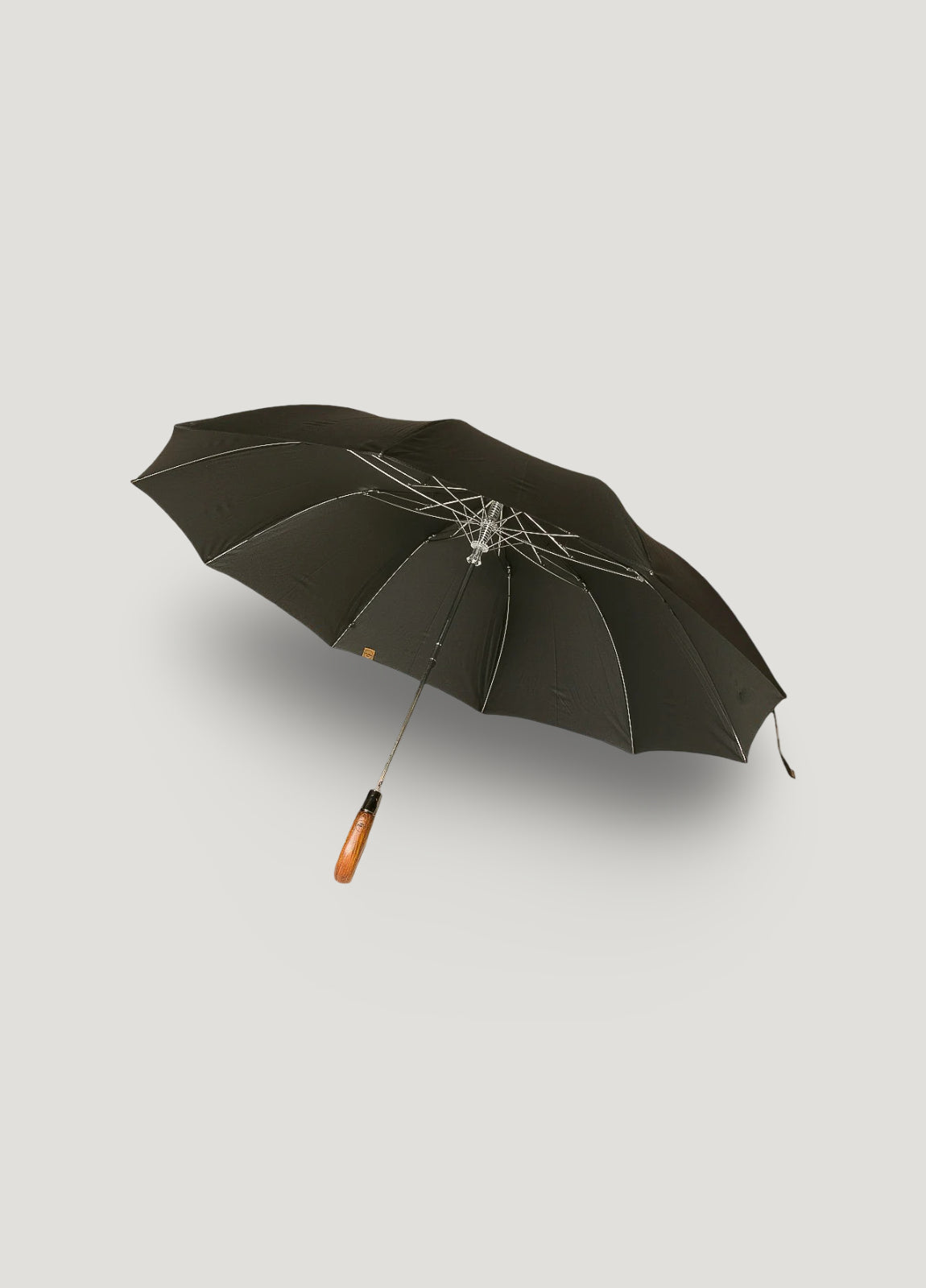 Paraguas plegable negro con puño de madera.