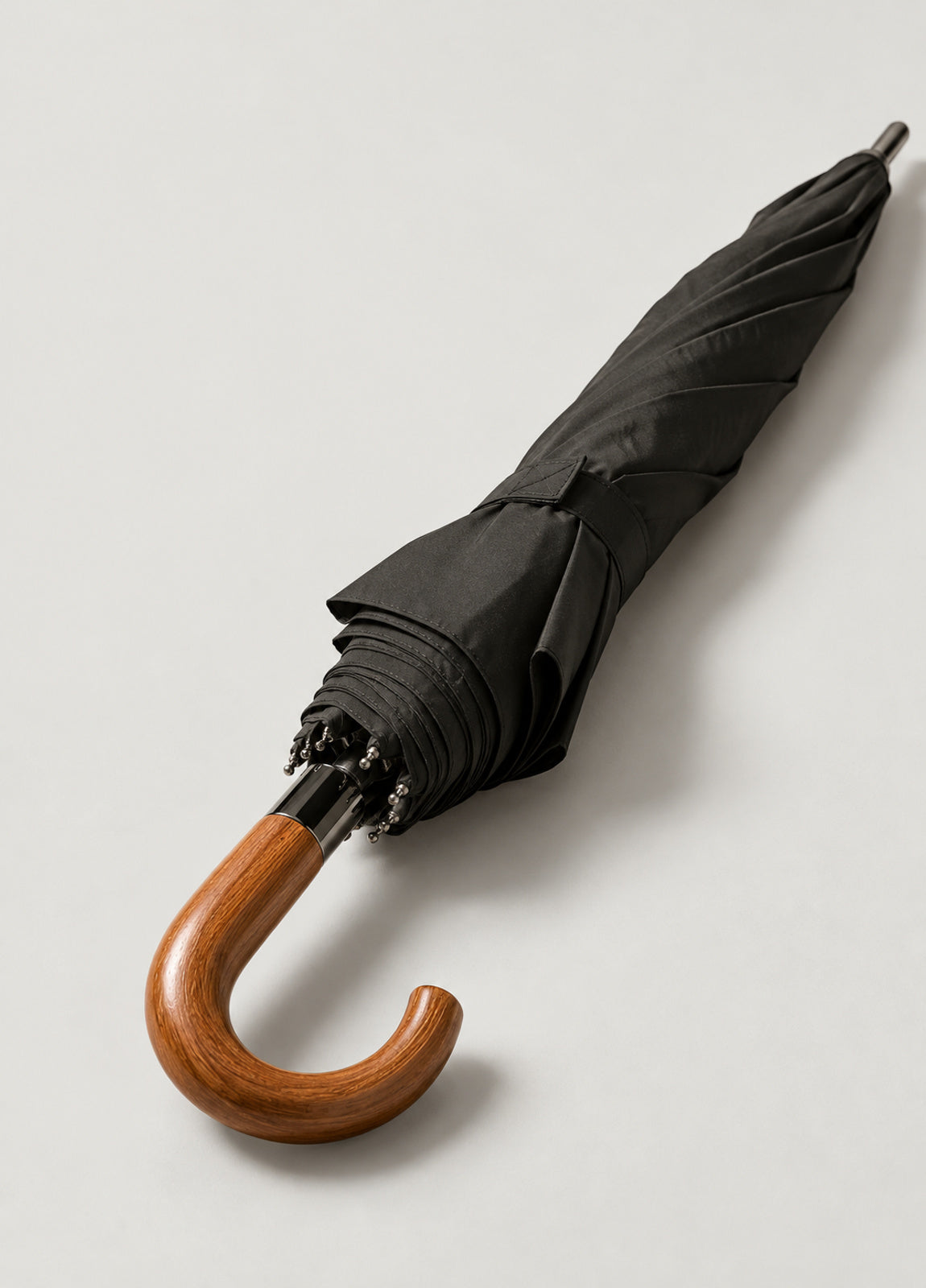 Paraguas plegable negro con puño de madera